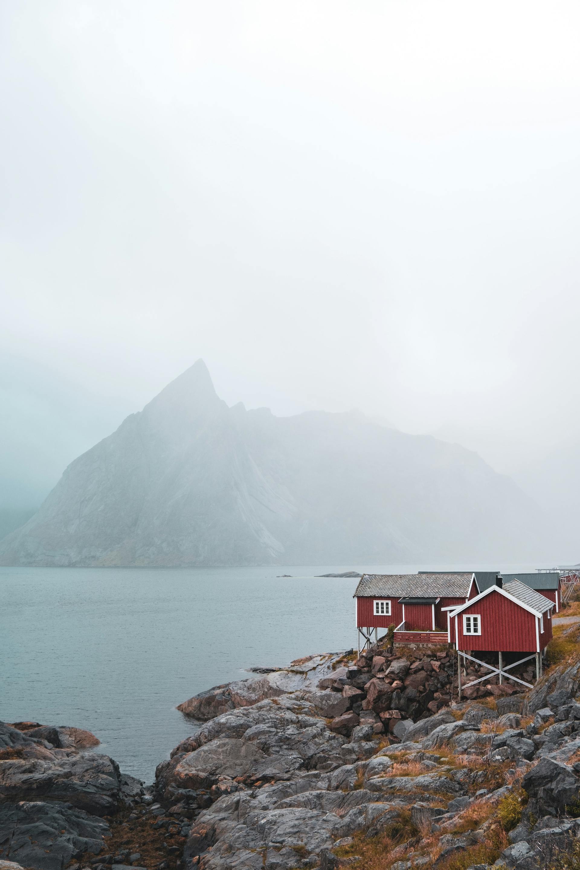 Photo of a red cabin on a foggy lake